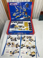 Box open showing 452 parts including metal strips, plates, screws, nuts, wheels, gears, and an instruction booklet.