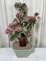Full view of the vintage artificial pink flower faux bonsai plant in ceramic pot with green leaves and pink flowers.