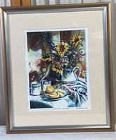 Framed vintage print of a still life titled 'Country Time Lemonade' showing pitcher with sunflowers, two ceramic mugs, and a plate of lemon slices.
