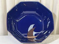 Front view of vintage octagonal cobalt blue plate showing flying crane design with gold accents.