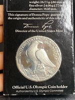 Close-up of coin and certification showing details of the silver content and authenticity signature of Donna Pope.