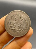 Front side of the silver coin showing Arabic calligraphy and the year 1355 in Islamic calendar.