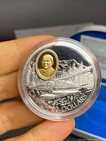 Close-up of the coin face showing floatplane and gold inset portrait