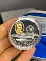 Coin front side showing Fairchild 71C floatplane with gold-colored portrait inset and 'CANADA 20 DOLLARS' inscription