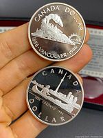 Coins front side showing commemorative designs of the Vancouver steam locomotive and Toronto skyline with locomotives