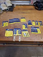 Overhead photo showing the full array of thirty-eight Irwin Hanson taps arranged on a workbench surface with visible packaging intact and unopened.