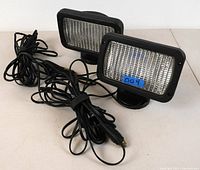 Two rectangular magnetic vehicle spotlights with attached long black power cords, shown from front angle.