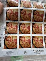 Close-up photo of a sheet of 2018 Canadian Year of the Dog stamps, showing the individual stamp design with a red and gold dog motif and text.