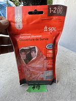 Front view of SOL HeatSheet survival blanket packaging, displaying branding and details for 1-2 person use.
