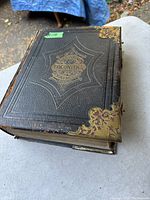 Top cover view showing embossed Welsh text on leather, decorative brass corners, and overall condition