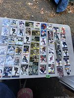 Wide view of multiple hockey cards arranged in rows on a table snow outdoors