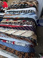 Large assortment of men's vintage ties with various patterns and colors laid out on table.