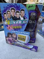 Front view of boxed *NSYNC Hot Zone fantasy phone and CD-ROM game, purple game device visible in plastic window with band images on box.