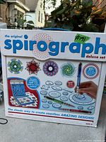 Box front of Original Spirograph Deluxe Set showing example designs, storage case, and components