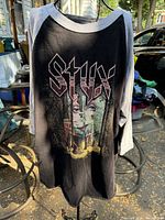 Front of STYX 1977 Tour T-shirt with raglan gray sleeves and black front with graphic and logo.