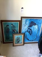 Full view of two Picasso Blue Period posters and one small framed floral painting