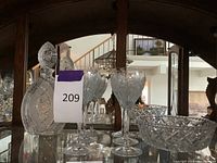 Photo showing the crystal decanter with stopper, six cocktail glasses, and the cut glass bowls reflected behind in mirror.