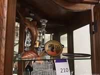 Crystal candleholders, Greek ceramic vase, Egyptian decorative plates inside glass cabinet