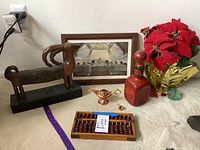 Assorted decor items viewed from above including ram sculpture, abacus, genie lamp, vase and poinsettia plant