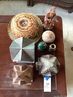 All lot items arranged on table showing varied decorative pieces including carved gourd, wooden figure, decorative houses and vases