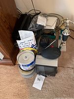 Full view of collection showing small Panasonic TV/radio, CD spindles, cables, mouse, trophies on carpet