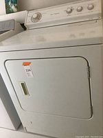 Front view of the white Whirlpool gas dryer showing door and handle.