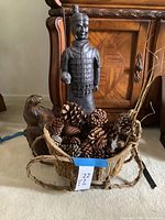 View showing all three items together: Terracotta Warrior statue, wood seal sculpture, and basket of pinecones