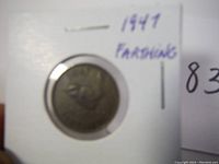 1947 British farthing coin front side showing King George VI in a protective holder with handwritten label.