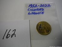 Image of a Canadian Loonie coin dated 1952-2022 with a colored airplane design on the coin surface.
