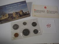 Overview of the six coins sealed in clear plastic from the 1976 Royal Canadian Mint specimen set along with two accompanying informational pamphlets.