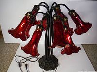 Front view showing ten red glass tulip-shaped shades and metal base