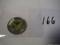 Top view of the Canadian two-dollar coin showing colored design in center and outer ring details.