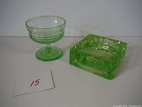 Photo showing two green Depression glass pieces: a pedestal dish and a square ashtray.