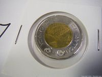 Close-up image of the front side of the 2017 Northern Lights Toonie showing the bi-metallic design with Northern Lights scene.