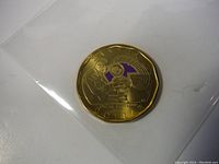 Photo showing the reverse of the coin with a musical motif and purple color inlay, sealed in plastic.