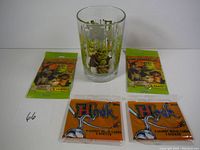Photo showing all items: two unopened Shrek movie card packs, two unopened Hook movie card packs with stickers, and one Shrek glass