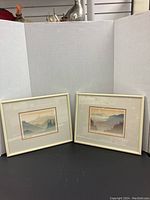 Two framed art prints displayed side-by-side on a black surface with white background, showing the overall appearance and framing.