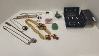 Wide view of various costume jewelry including necklaces, brooches, earrings, and pins laid out on white surface