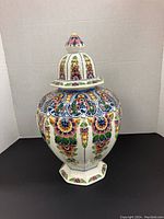 Front view of large ginger jar with lid showing colorful floral design.
