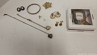 Full lot of vintage jewelry displayed, including bracelet, earrings, brooch, and necklaces