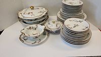 Stack of oval covered casseroles, gravy boat with underplate, round covered dish and plate stacks