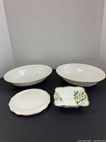 Three dishes arranged together, two large white oval casserole dishes with gold edge and a smaller square dish showing dogwood flower pattern.