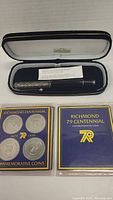 Silver Sheaffer rollerball pen in decorative cap, inside blue velvet-lined case with gold trim and label inside lid, accompanied by two Richmond Centennial commemorative coin sets in plastic holders with original purple and gold booklets.