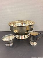 Silver-plated large ice bucket, creamer, and sugar bowl grouped together showing size and finish