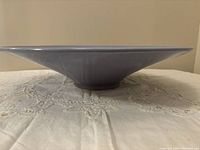 Side profile of the periwinkle pottery bowl showing its wide flared shape and base.