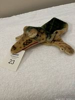 Photo showing the alligator hand puppet laid flat on a white surface highlighting its detailed head, mouth, and limb structure.