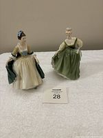 Photo showing both figurines side by side on white cloth, captures full figure and color details