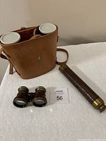 Full view of all three items including leather binoculars case, small field glasses, and brass spyglass telescope on white surface
