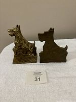 Front and back views of the paired brass Scotty dog bookends showing detailed sculpture and shape