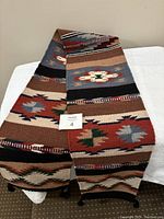Folded view of Southwestern wool runner showing geometric and diamond patterns in warm earth tones